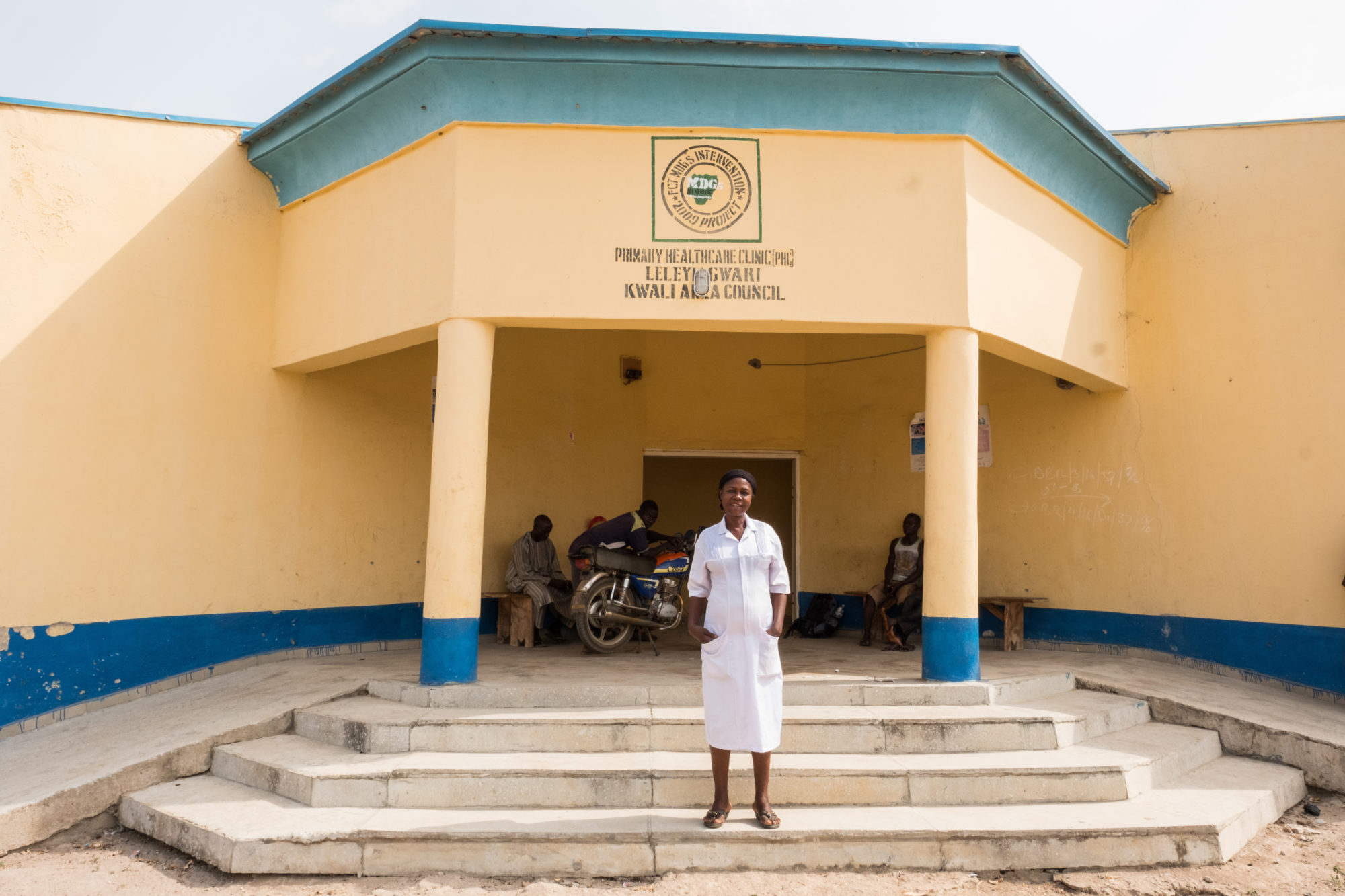 Orji Theresa stands in front of the hospital she works at in Nigeria.