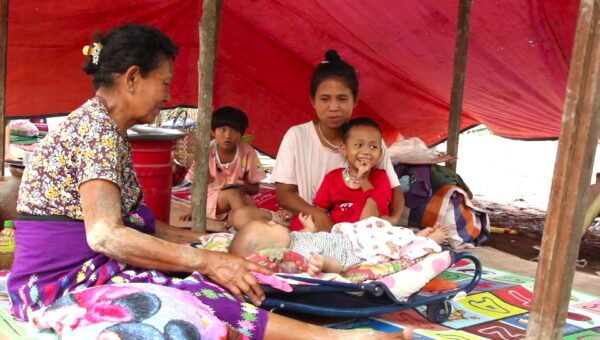 Aye Aye Aung (pictured right) with her family in a makeshift shelter, two weeks after the earthquake